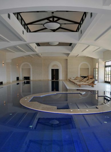 Vue de la piscine intérieure avec portes-fenêtres avec fuseruoli en arrière-plan