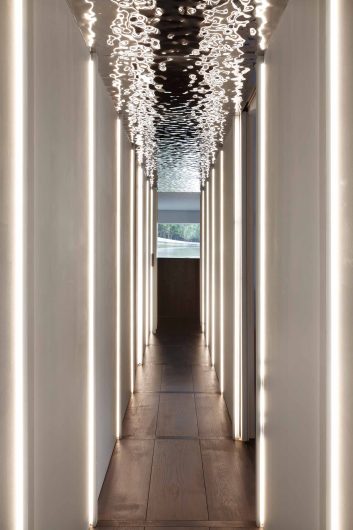 Détail du couloir, avec des jeux de lumière réfléchis par le plafond métallique